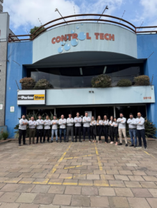 A imagem mostra a equipe da Control Tech em frente à fachada da empresa